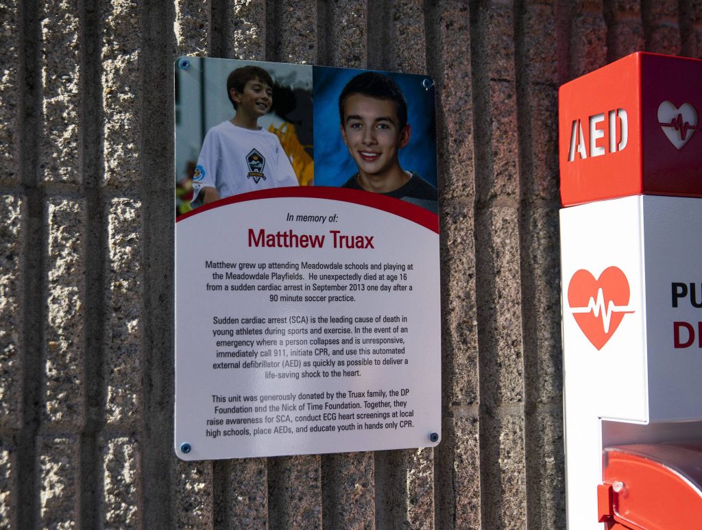 A sign in memory of Matthew Truax is mounted next to the new AED at the Meadowdale Athletic Complex on Friday, Oct. 6, 2023 in Lynnwood, Washington. (Olivia Vanni / The Herald)