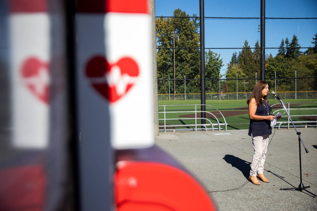 Melinda Truax, mother of Matthew Truax, speaks at a ribbon cutting for the unveiling of a newly installed AED at the Meadowdale Athletic Complex on Friday, Oct. 6, 2023 in Lynnwood, Washington. (Olivia Vanni / The Herald)