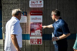 People gather to look at the new AED available for emergency use at the Meadowdale Athletic Complex on Friday, Oct. 6, 2023 in Lynnwood, Washington. (Olivia Vanni / The Herald)