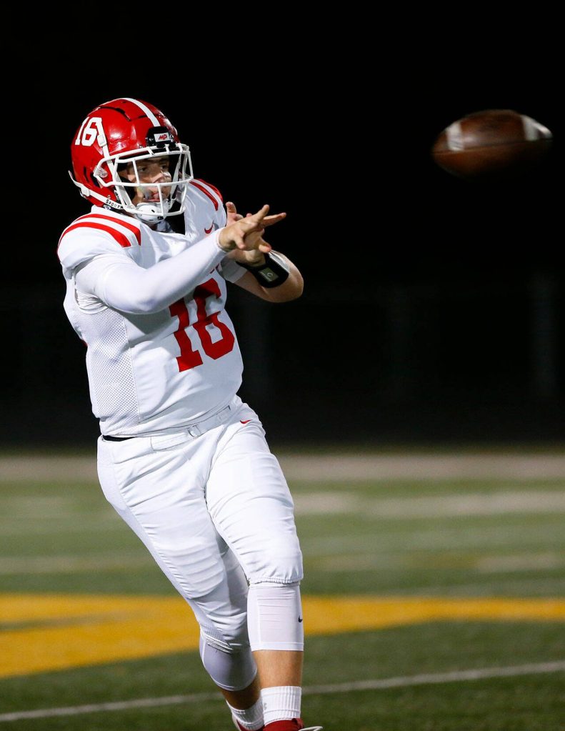 Marysville Pilchuck senior quarterback Luke Shoemaker completes a short pass on the run against Arlington on Friday, Oct. 6, 2023, at Arlington High School in Arlington, Washington. (Ryan Berry / The Herald)