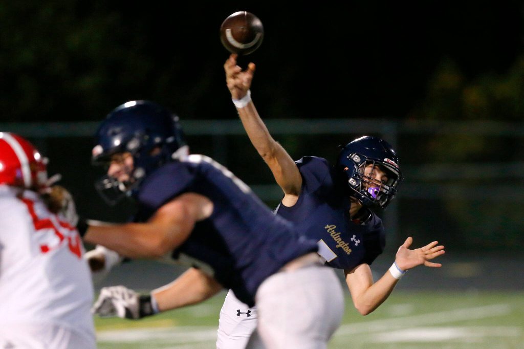 Arlington junior quarterback Leyton Martin completes a pass up the middle against Marysville Pilchuck on Friday, Oct. 6, 2023, at Arlington High School in Arlington, Washington. (Ryan Berry / The Herald)