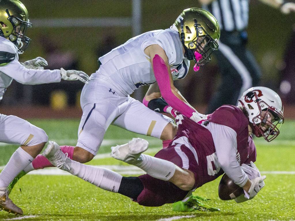 Cascades Benjamin Robinson is tackled while running the ball during the game against Everett on Friday, Oct. 6, 2023 in Everett, Washington. (Olivia Vanni / The Herald)