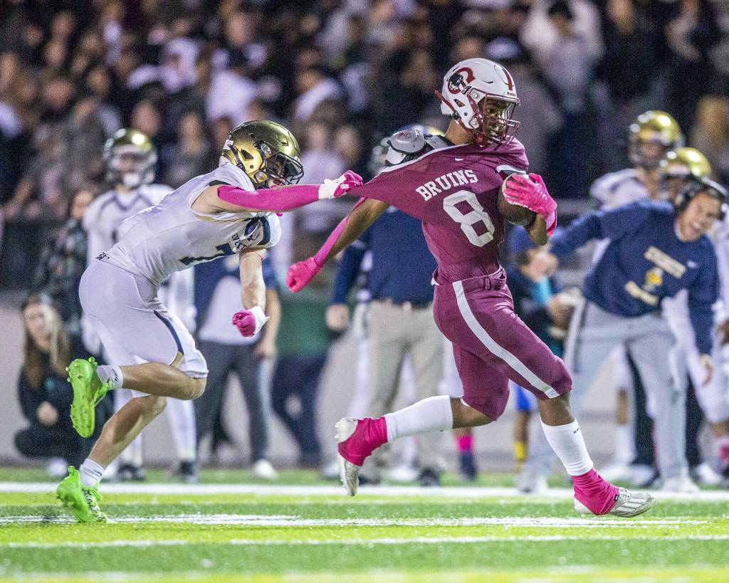 Everetts lan Hendry grabs the jersey of Cascades Andi Cosme while he runs the ball during the game on Friday, Oct. 6, 2023 in Everett, Washington. (Olivia Vanni / The Herald)
