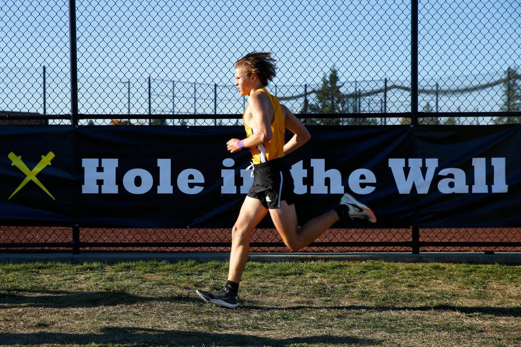 An athlete approaches the final stretch of the Mens Elite run during the Hole in the Wall Cross Country Invitational on Saturday, Oct. 7, 2023, at Lakewood High School in Arlington, Washington. (Ryan Berry / The Herald)
