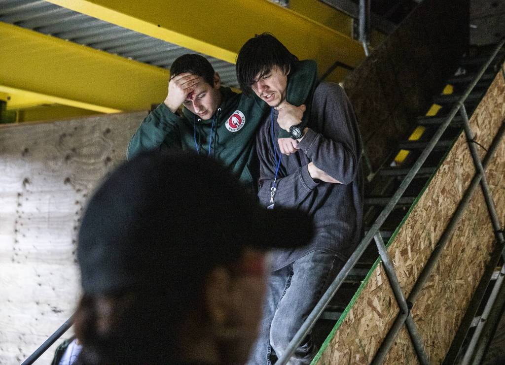 Two wounded victims make their way down a flight of stairs while being directed by Everett SWAT during a mass casualty training on Wednesday, Oct. 11, 2023 in Snohomish, Washington. (Olivia Vanni / The Herald)