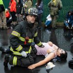Snohomish firefighter Joshua Poole talks with another firefighter while administering aid to a victim during a mass casualty training on Wednesday, Oct. 11, 2023 in Snohomish, Washington. (Olivia Vanni / The Herald)