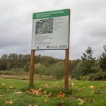 A sign off of the Whitehorse Trail displaying plants for the Trafton Trailhead Park restoration on Monday, Oct. 16, 2023 in Arlington, Washington. (Olivia Vanni / The Herald)