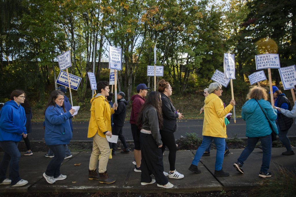 Everett Public Schools paraeducators holding signs protest outside of the Everett School Board meeting for better wages on Tuesday, Oct. 10, 2023 in Everett, Washington. (Olivia Vanni / The Herald)