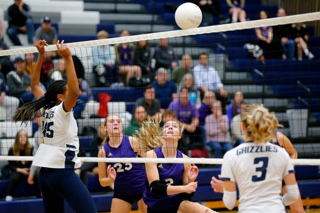 Lake Stevens and Glacier Peak players both watch as the ball teeters on the net on Tuesday, Oct. 10, 2023, at Glacier Peak High School in Snohomish, Washington. (Ryan Berry / The Herald)
