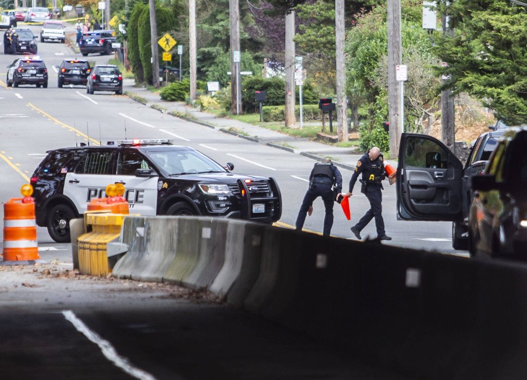 Everett police officers mark evidence along East Casino Road in front of Cascade High School on Friday, Oct. 13, 2023 in Everett, Washington. (Olivia Vanni / The Herald)