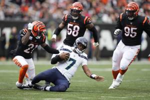 Seattle Seahawks quarterback Geno Smith slides in front of Cincinnati Bengals Mike Hilton (21) during the second half of Sundays game in Cincinnati. (AP Photo/Michael Conroy)