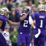 Washington wide receiver JaLynn Polk (2) reacts with Will Nixon, left, after scoring a touchdown against Oregon during a game Oct. 14 in Seattle. (AP Photo/Lindsey Wasson)