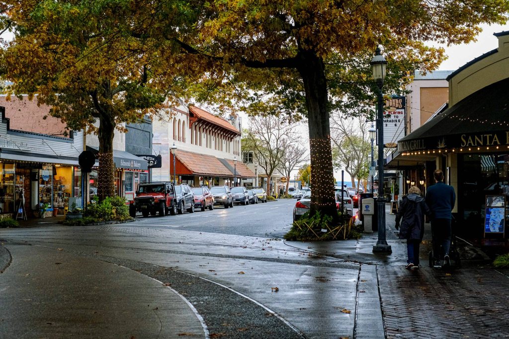 Two people walk down the side walk in downtown Edmonds. (Taylor Goebel / The Herald file)