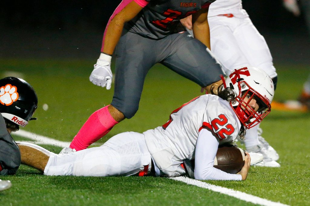 Kings quarterback Noah Clark falls forward with the ball against Granite Falls on Friday, Oct. 20, 2023, at Granite Falls High School in Granite Falls, Washington. (Ryan Berry / The Herald)