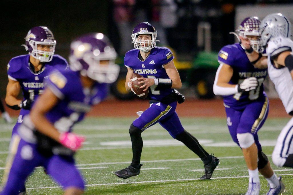 Lake Stevens Kolton Matson rolls out of the pocket while looking to throw downfield against Glacier Peak on Oct. 28, 2022, at Lake Stevens High School. (Ryan Berry / The Herald)