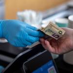 Cash is used for a purchase at Molly Moon's Ice Cream in Edmonds, Washington on Wednesday, Aug. 30, 2023. (Annie Barker / The Herald)
