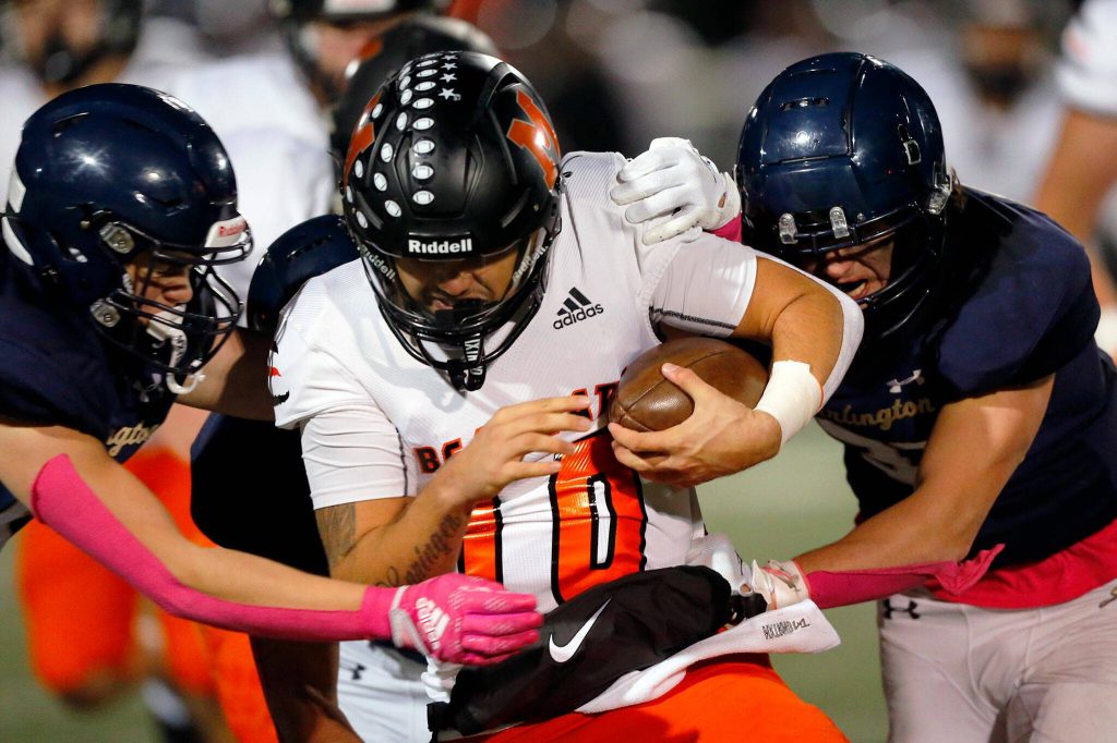 Monroe quarterback Blake Springer is sacked by a gang of Arlington Eagles on Friday, Oct. 27, 2023, at Arlington High School in Arlington, Washington. (Ryan Berry / The Herald)