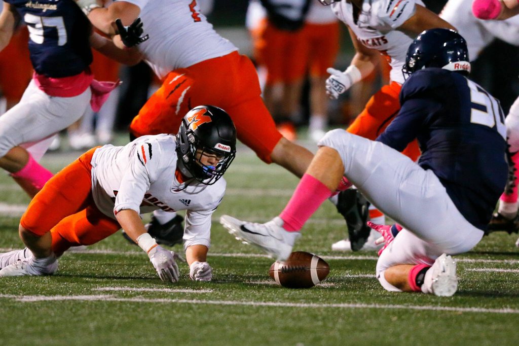 Monroe and Arlington players scramble for a fumble during a game on Friday, Oct. 27, 2023, at Arlington High School in Arlington, Washington. (Ryan Berry / The Herald)