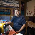 Sam Taylor, 73, in one of his painting spaces in his home in Everett. He uses drop cloths, burlap and house paint to create art. Im kind of the Home Depot artist, Taylor said. (Olivia Vanni / The Herald)