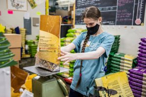 Gillian Montgomery weighs a bag of bird seed at Wild Birds Unlimited on Monday, Oct. 23, 2023 in Everett, Washington. (Olivia Vanni / The Herald)