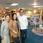 Manager Rika Rafael, left, visual merchandiser April Votolato, center, and assistant manager and events coordinator Jaidhara Sleighter stand at the entrance of East West Books & Gifts new location Friday, Oct. 27, 2023, in downtown Edmonds, Washington. (Ryan Berry / The Herald)