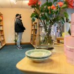 A customer scans the bookshelves at East West Books & Gifts on Friday, Oct. 27, 2023, in Edmonds, Washington. (Ryan Berry / The Herald)