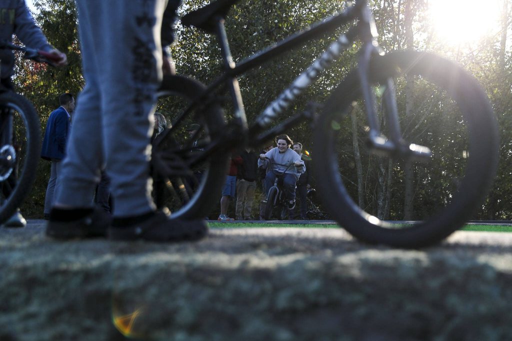 Kids, teens and adults try out a new pump track for bikes at Jennings Nature Park in Marysville. (Annie Barker / The Herald)