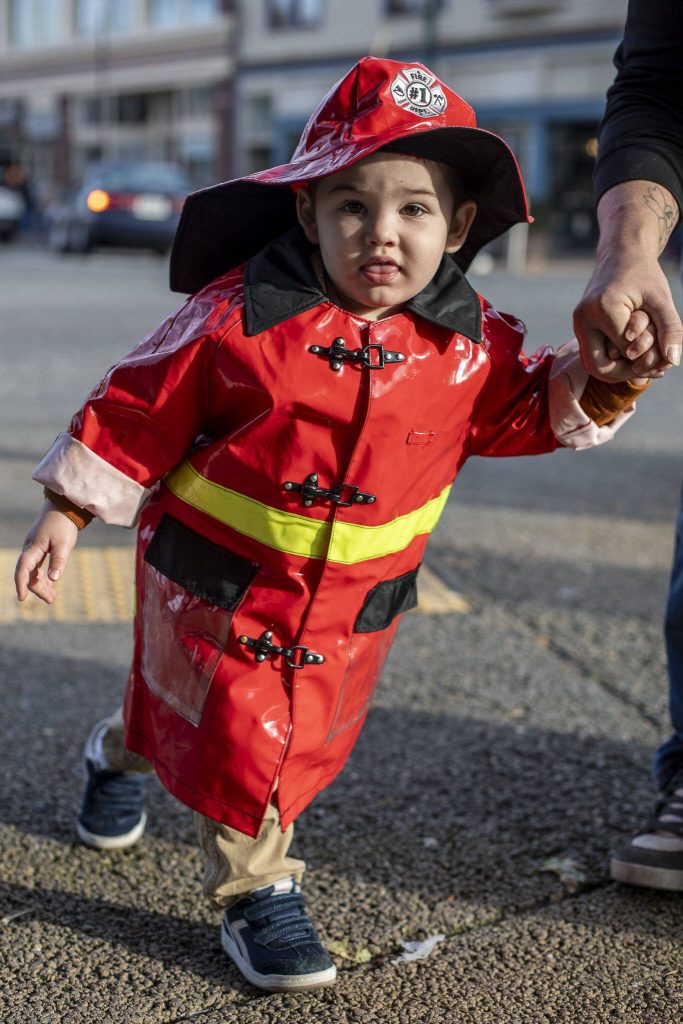 Ernest Salvator-Thaete, 2, poses for a photo during the Downtown Trick or Treat event in Monroe, Washington on Tuesday, Oct. 31, 2023. Children, teens and families walked Main Street to collect candy from local businesses. Dogs sported costumes as well and decorations adorned buildings. (Annie Barker / The Herald)