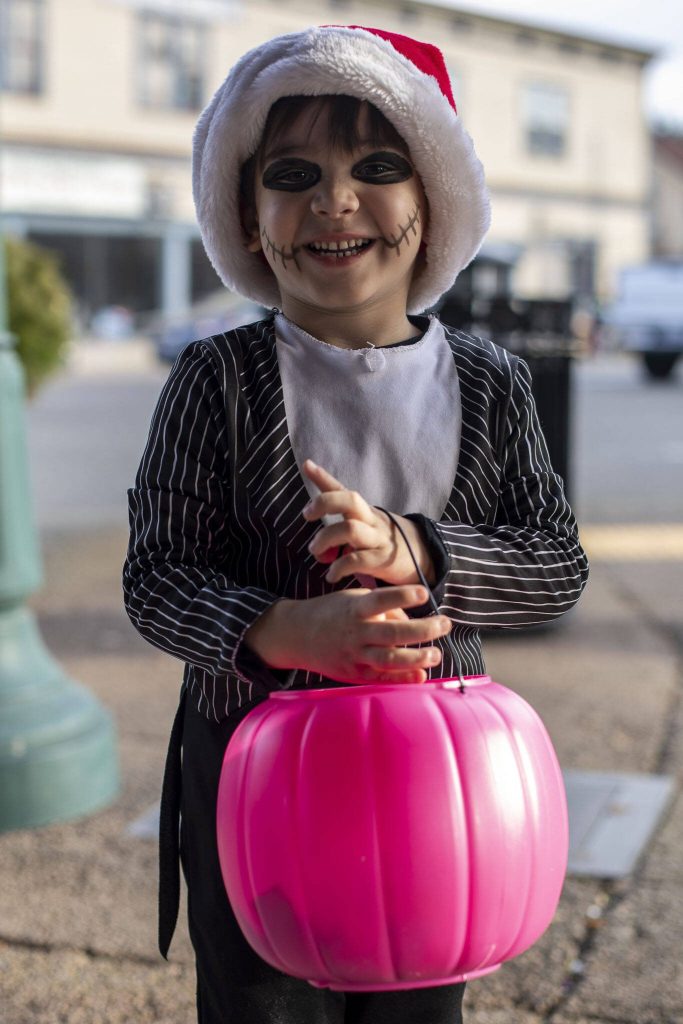 Callum, 3, poses for a photo during the Downtown Trick or Treat event in Monroe, Washington on Tuesday, Oct. 31, 2023. Children, teens and families walked Main Street to collect candy from local businesses. Dogs sported costumes as well and decorations adorned buildings. (Annie Barker / The Herald)