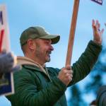 Snohomish County Sheriff Adam Fortney waves signs with supporters along Highway 9 on Monday, Nov. 6, 2023, in Arlington, Washington. (Ryan Berry / The Herald)