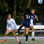 Everett defender Bella Nguon collides with another player while heading the ball away during a district playoff matchup against Oak Harbor on Thursday, Nov. 2, 2023, at Shoreline Stadium in Shoreline, Washington. (Ryan Berry / The Herald)