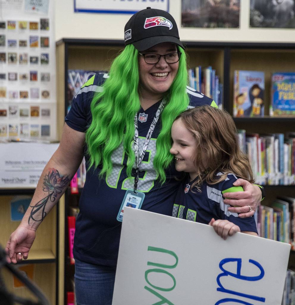 Crystal Moore, left, holds her duaghter Londyn Moore, 9, right, after she is surprised with a $2,000 cash donation through the Premera Heroes in the Classroom program at Silver Lake Elementary in Everett, Washington on Friday, Nov. 3, 2023. (Annie Barker / The Herald)