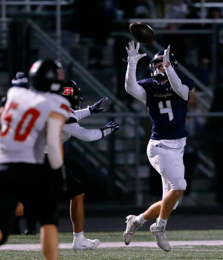 Arlington junior wideout Jake Willis hauls in a long throw against Ballard during a playoff matchup Friday, Nov. 3, 2023, at Arlington High School in Arlington, Washington. (Ryan Berry / The Herald)
