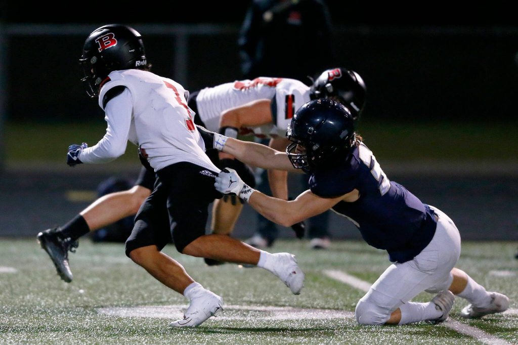 Ballards Keith Stout slips a tackle by Arlingtons Kobi Spady during a playoff matchup Friday, Nov. 3, 2023, at Arlington High School in Arlington, Washington. (Ryan Berry / The Herald)