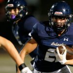 Arlington running back Caleb Reed takes a handoff against Ballard during a playoff matchup Friday, Nov. 3, 2023, at Arlington High School in Arlington, Washington. (Ryan Berry / The Herald)