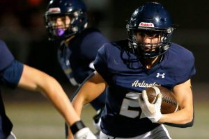 Arlington running back Caleb Reed takes a handoff against Ballard during a playoff matchup Friday, Nov. 3, 2023, at Arlington High School in Arlington, Washington. (Ryan Berry / The Herald)