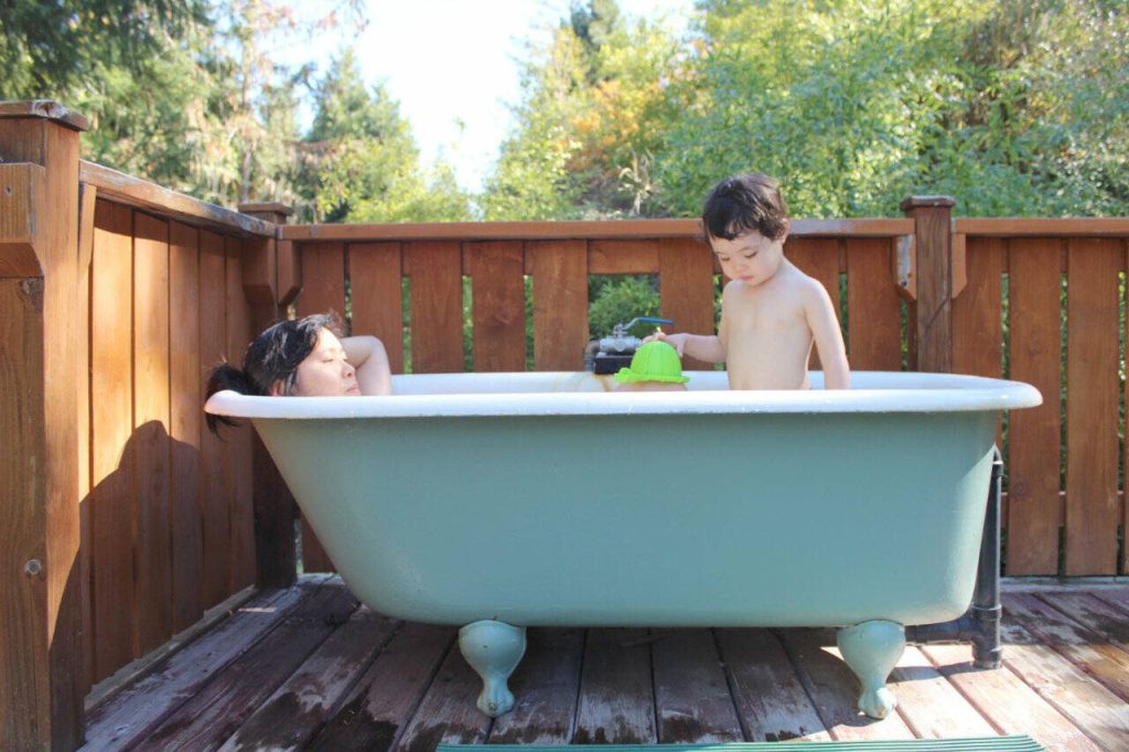 The authors wife and daughter relax in a bathtub filled with geothermal mineral water at Breitenbush Hot Springs in central Oregon. (Gregory Scruggs / The Seattle Times)