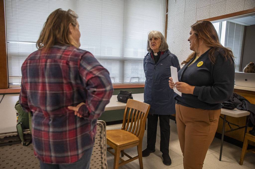 Chair of the governing board of the Faith Action Network Rev. Carol Jensen, center, speaks to others after a press confrence for the Providence nurses who gave a 10-day strike notice two days ago at the Everett Labor Temple in Everett, Washington on Monday, Nov. 6, 2023. (Annie Barker / The Herald)
