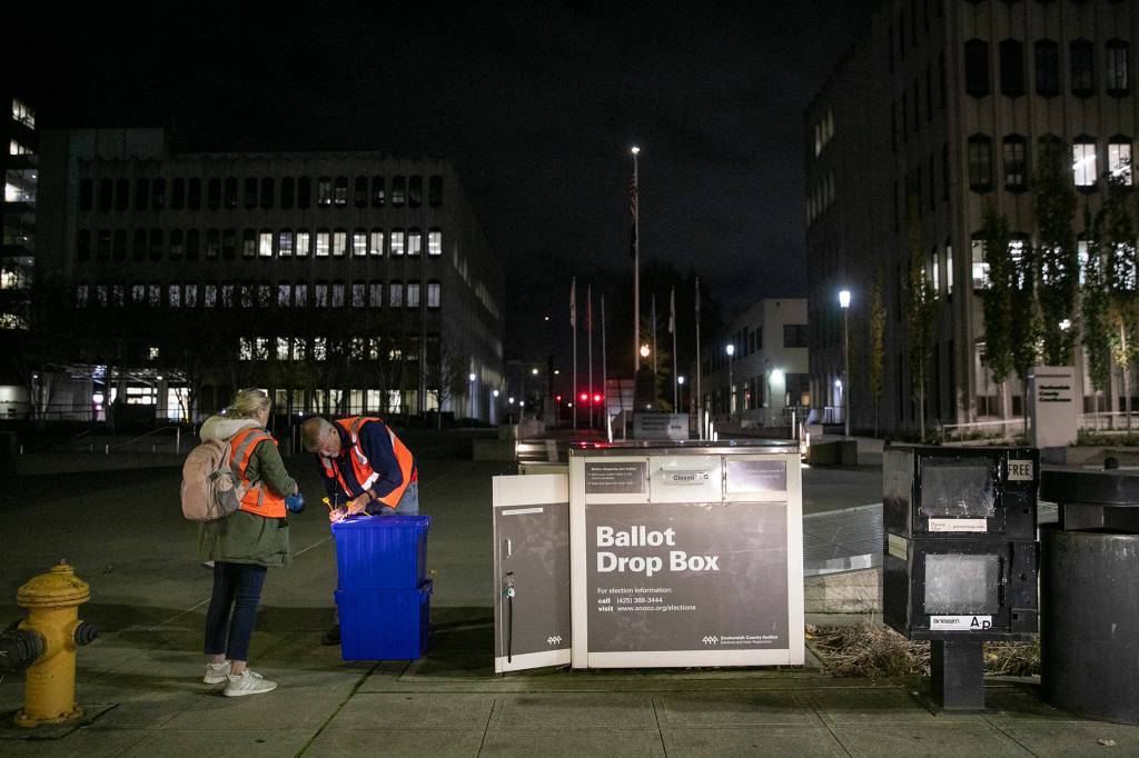 Two election workers seal up boxes of ballots after closing the county courthouse ballot box at 8 p.m. Tuesday, Nov. 7, 2023, in downtown Everett, Washington. (Ryan Berry / The Herald)
