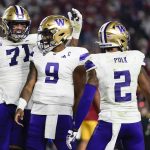 Washington offensive lineman Nate Kalepo (71) and quarterback Michael Penix Jr. (9) celebrate after a touchdown by wide receiver JaLynn Polk (2) during a game against Southern California on Nov. 4 in Los Angeles. (AP Photo/Ryan Sun)