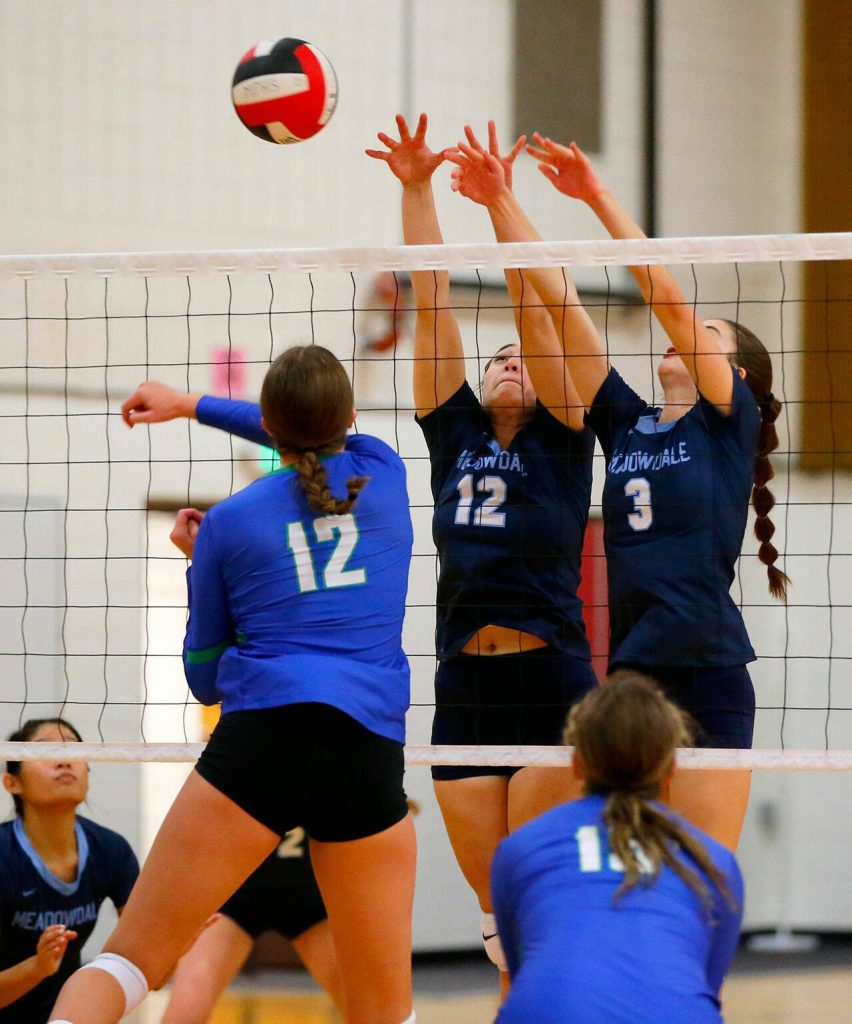 Two Meadowdale blockers successfully make a stop during a Class 3A District 1 volleyball match against Shorewood on Thursday at Marysville Pilchuck High School in Marysville. (Ryan Berry / The Herald)
