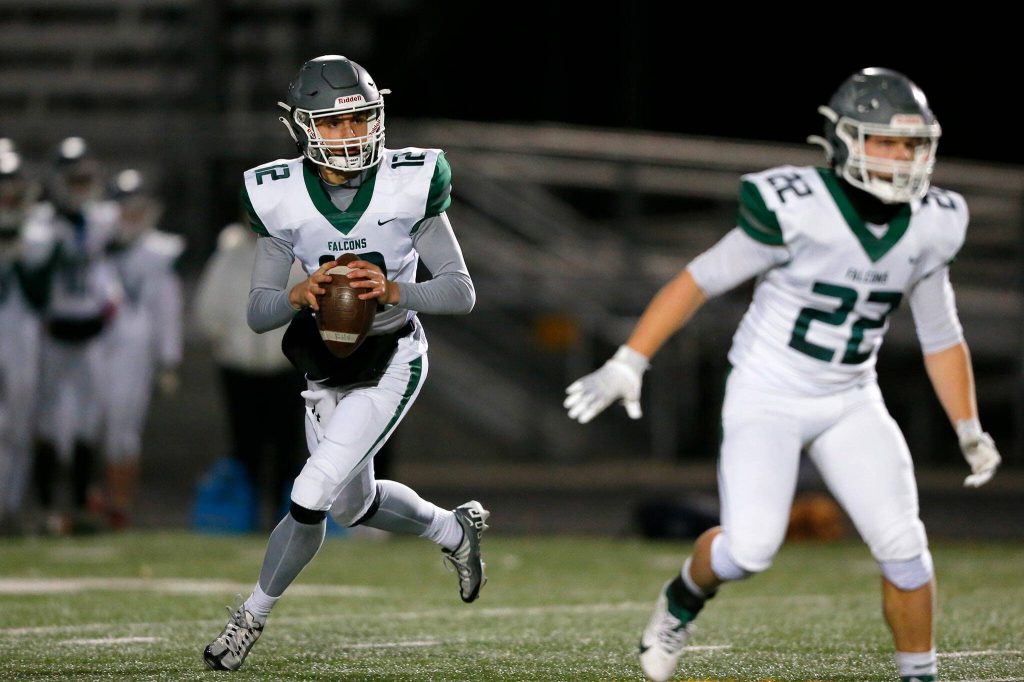 Ridgeline quarterback Landon Garner looks for a receiver against Arlington during a playoff matchup Friday, Nov. 10, 2023, at Arlington High School in Arlington, Washington. (Ryan Berry / The Herald)