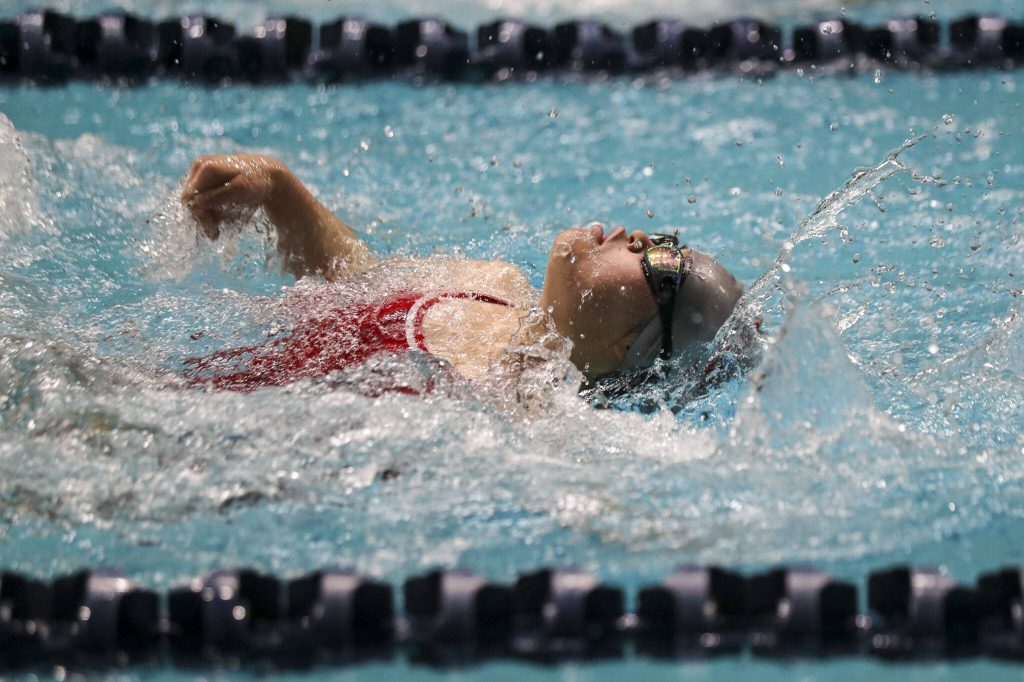 Stanwoods Miya Watanabe performs in the 50-yard backstroke adaptive race during the 3A girls state swim and dive championships at King County Aquatic Center in Federal Way, Washington on Saturday, Nov. 11, 2023. (Annie Barker / The Herald)