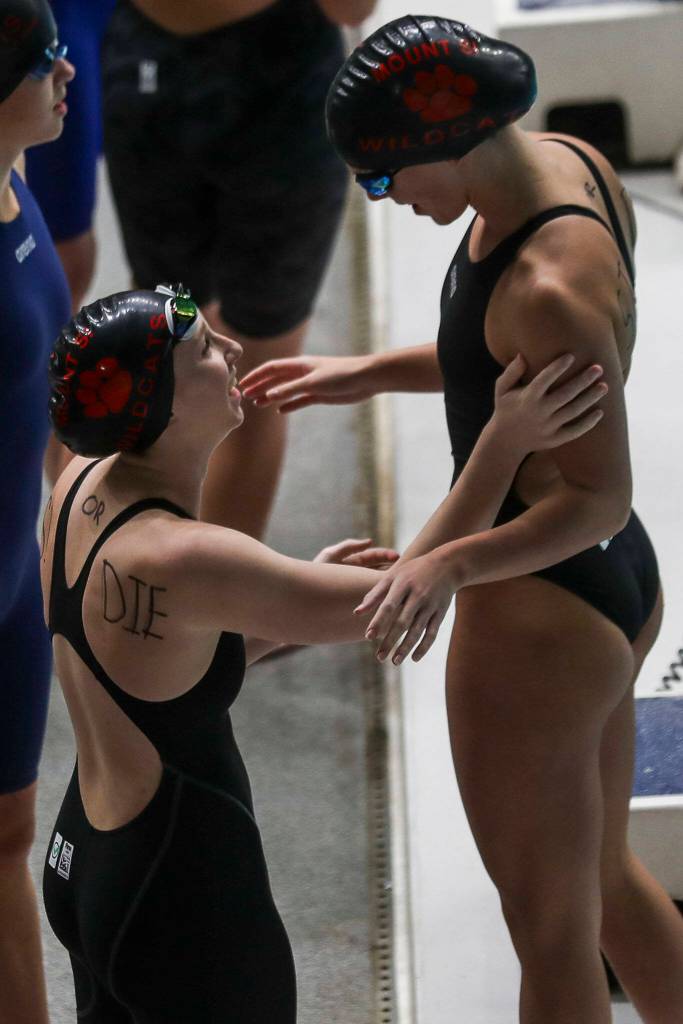 Swimmers talk before the 4A girls state swim and dive championships at King County Aquatic Center in Federal Way, Washington on Saturday, Nov. 11, 2023. (Annie Barker / The Herald)