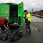 Evan Reed, right, receives help from Mike Watson loading up bags of litter collected along Marine View on Sunday, Nov. 19, 2023, in Everett, Washington. Reed, Watson and two others managed to fill ten bags of trash in two hours before taking the trash to a dumpster along the waterfront.(Ryan Berry / The Herald)