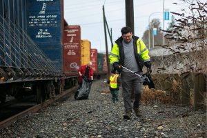 Evan Reed heads back to his vehicle after a few hours of picking up litter along Marine View on Sunday, Nov. 19, 2023, in Everett, Washington. Reed started out cleaning up trash on his own, but has gained a few volunteers via the website Reddit. (Ryan Berry / The Herald)
