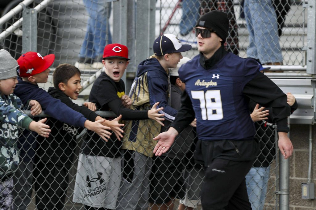 Arlington players take the field during the Arlington and Bellevue Class 3A state quarterfinal game at Arlington High School in Arlington, Washington on Saturday, Nov. 18, 2023. Arlington lost, 35-17. (Annie Barker / The Herald)