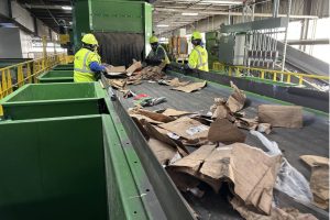 Workers at MW's Cascade Recycling Center in Woodinville remove large unrecyclable materials, like plastic sheeting, from a conveyor belt. Optical scanners and other equipment sort most of the material processed at the center. (The Herald)