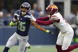 Seattle Seahawks wide receiver Tyler Lockett runs the ball against Washington Commanders cornerback Danny Johnson, right, during the first half of an NFL football game, Sunday, Nov. 12, 2023, in Seattle. (AP Photo/Lindsey Wasson)