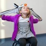 Charley plays with her penguin hat as she answers questions during an interview with the Herald on Monday, Nov. 20, 2023, at Jackson Elementary School in Everett, Washington. Charley does not own a turkey hat. (Ryan Berry / The Herald)